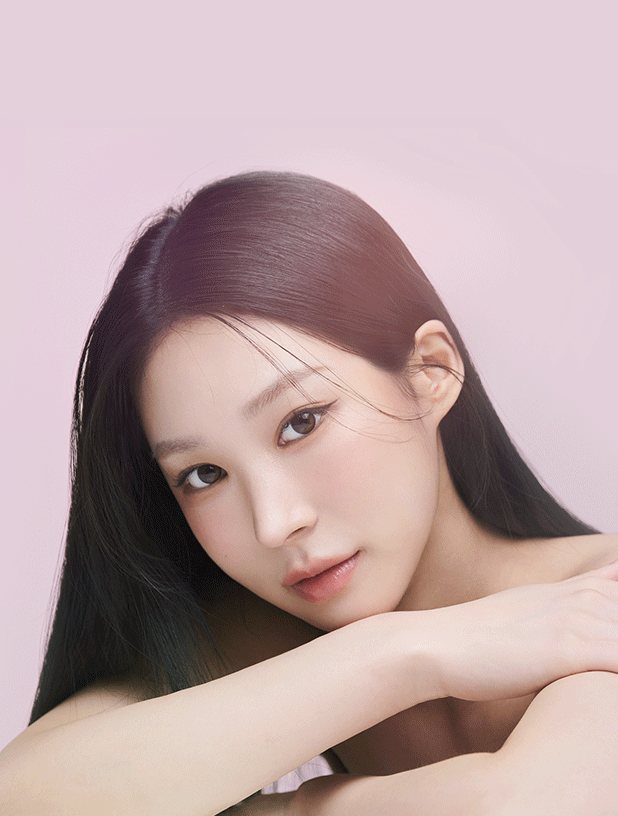 연분홍 배경, 팔을 포개고 엎드려 정면을 보는 긴 생머리 여성 모델