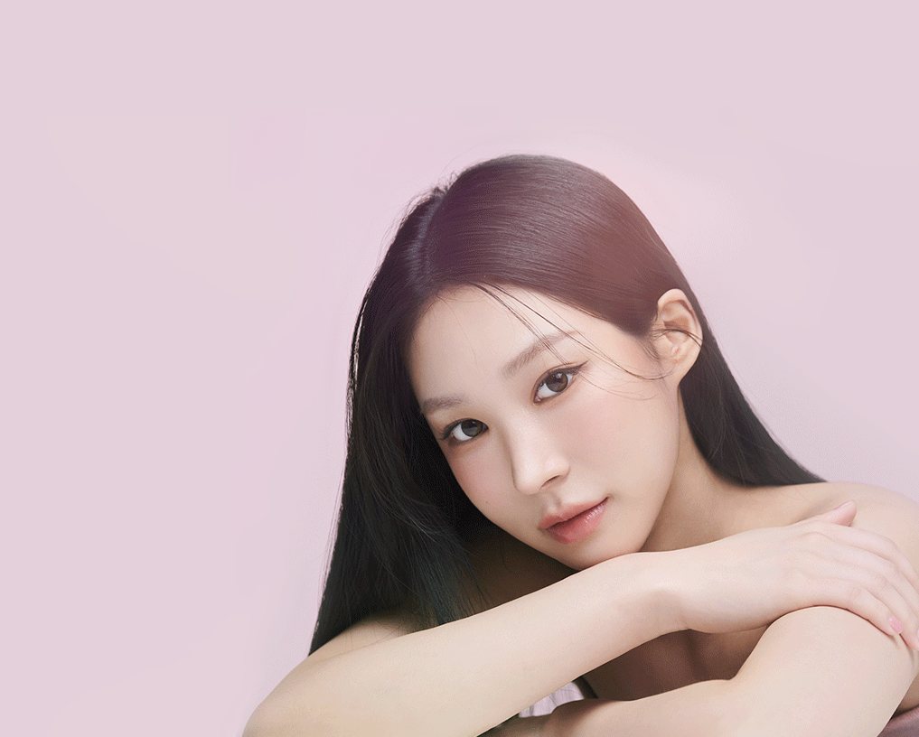 연분홍 배경, 팔을 포개고 엎드려 정면을 보는 긴 생머리 여성 모델